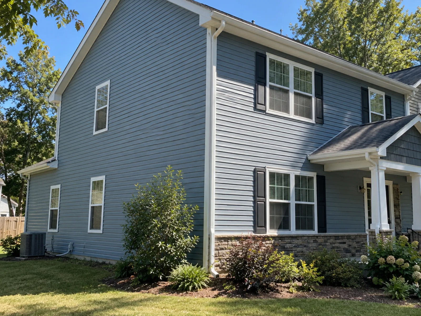 Two-storey home with blue-grey lap siding, white trim and a stone skirt